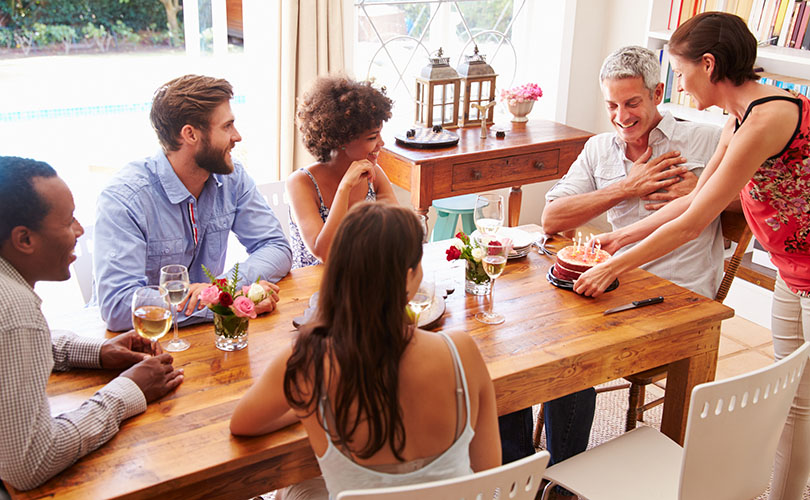 Friends sitting at a dining table celebrating a birthday